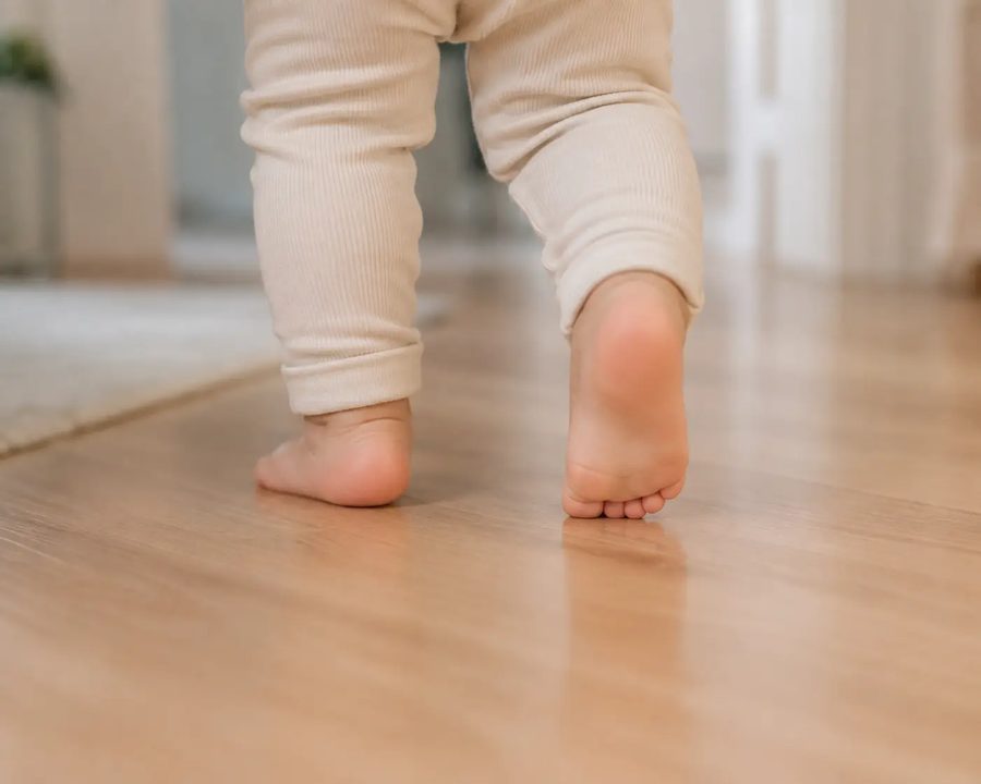 Pés de bebê dando os primeiros passos, referência à puericultura